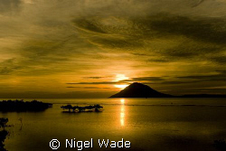 Sunset over Manado Tua. Pure Gold. by Nigel Wade 